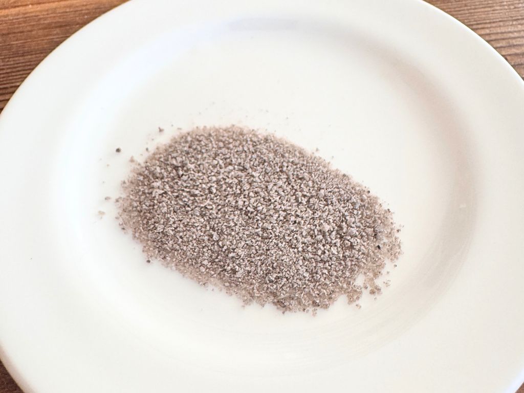 宮崎県の本格土窯で焼き上げられた「竹炭の里・窯焼き竹塩」。竹のエキスが染み込み、ほんのりと茶色く色づいたパウダー状の塩の写真。