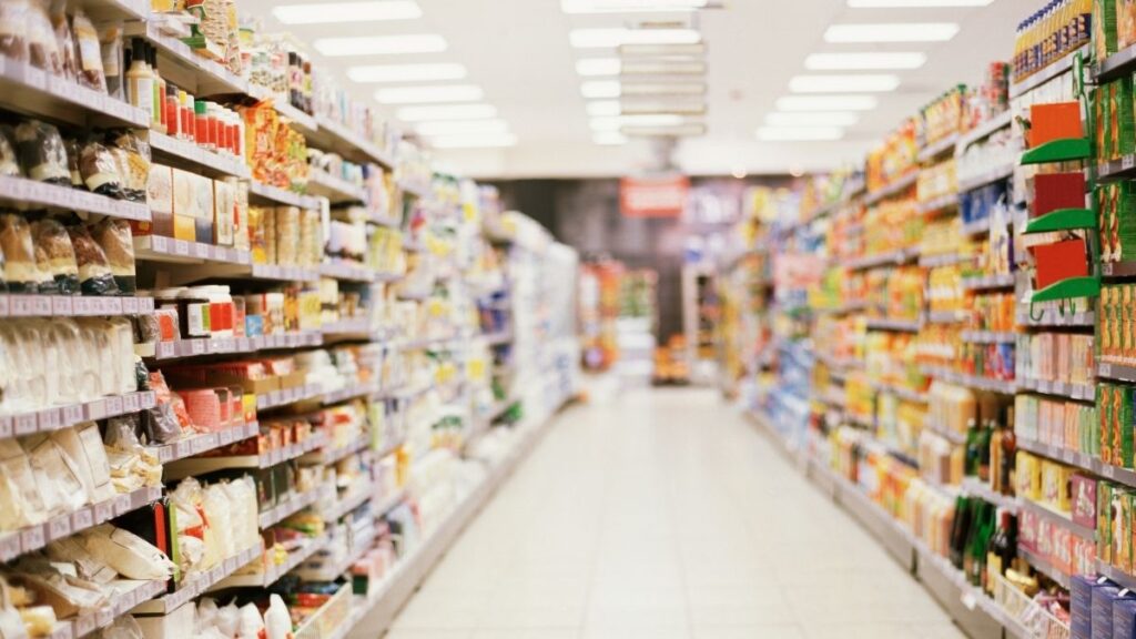 スーパーマーケットの陳列棚に、精製塩や天然塩など様々な種類の塩のパッケージがずらりと並んでいる様子。