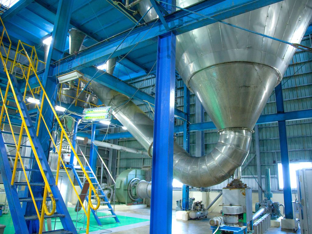 八重山殖産のクロレラ製造工場内部。清潔なステンレス製のタンクや配管が並び、徹底した衛生管理が行われている様子。