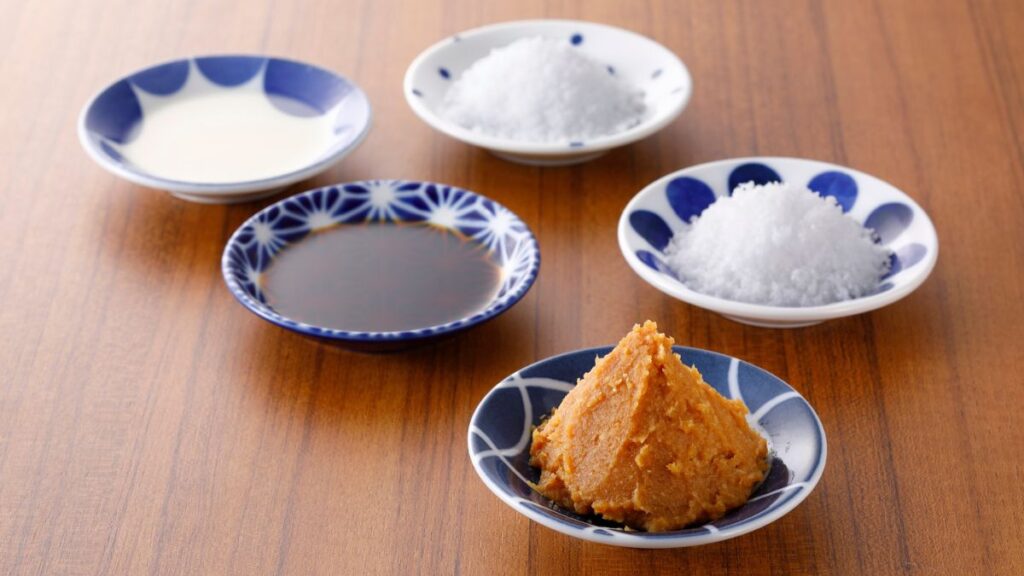 小皿に盛られた日本の発酵調味料。味噌、醤油、塩、甘酒が並んでいる