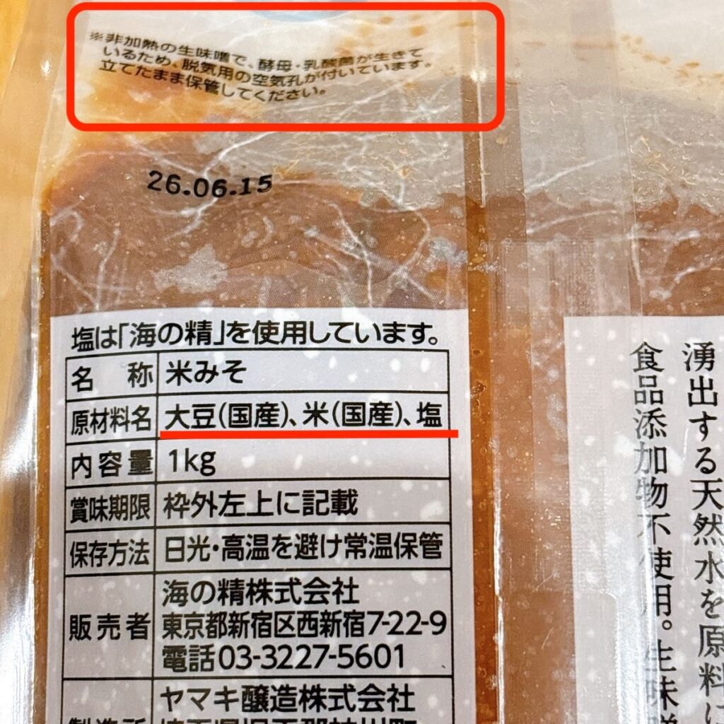 本物の味噌の原材料表示。「大豆（国産）、米（国産）、塩」の3つだけが赤線で強調されている。上部には「非加熱の生味噌で、酵母・乳酸菌が生きている」の表記