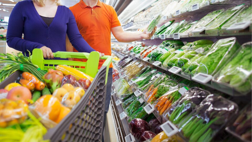 スーパーマーケットの青果売り場に並ぶ新鮮な野菜と、産地表示（国産）のラベル