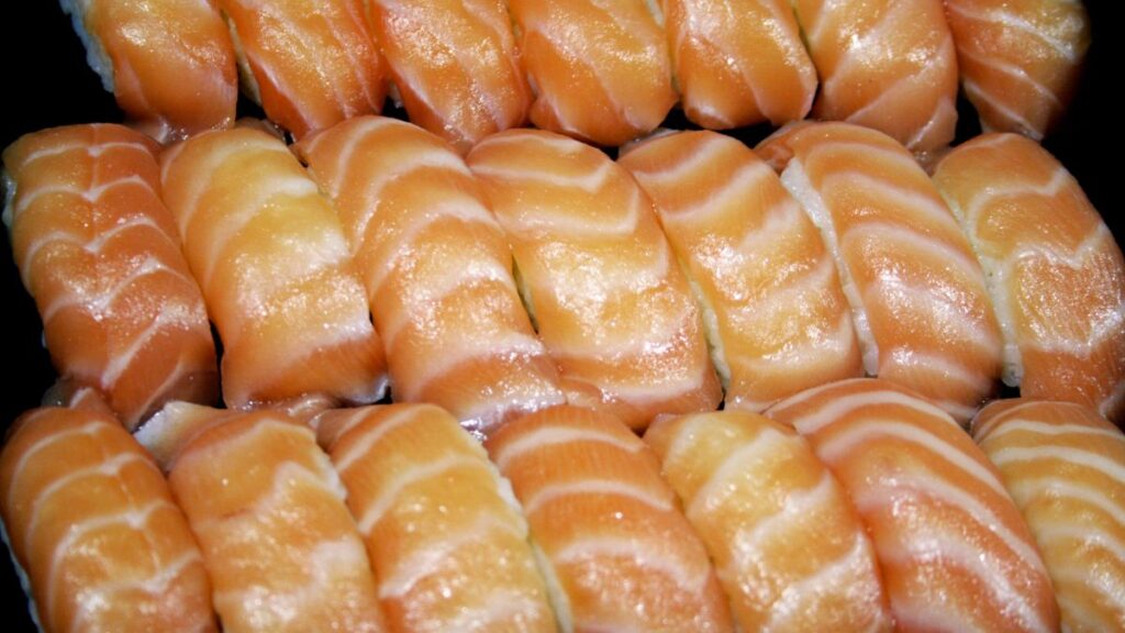 「ずらりと並んだサーモンの握り寿司。一見、脂がのって体に良さそうに見えるこのオレンジ色は、飼料に添加された色素で作られたものだ。」