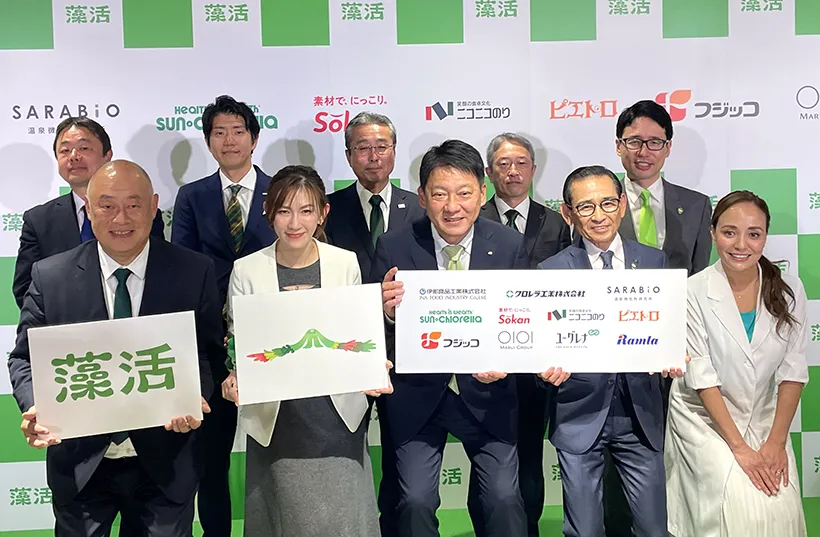 2025年12月に発足した「藻活（もかつ）推進プロジェクト」の記者発表会。ユーグレナ社をはじめ、サンクロレラ、クロレラ工業、フジコ、ニコニコノリ、ピエトロなど11社の代表者が「藻活」のロゴを掲げて記念撮影。