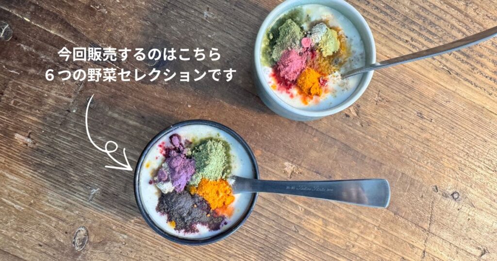 木のテーブルの上に置かれた2つの器に甘酒が入っており、その上に緑、紫、赤、黄色など色の異なる粉末がのせられている様子